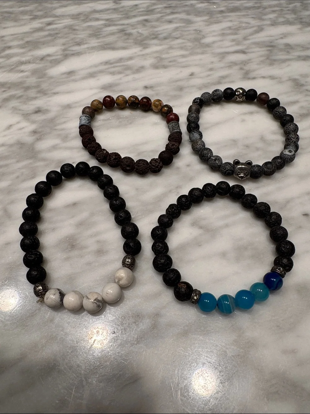Set of 4 black and multi stone stretch bracelets. One with silver bear head bead